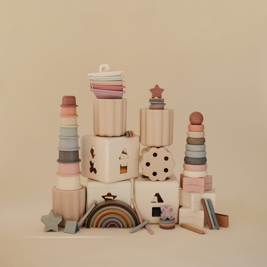 Stacks of colorful wooden toys on a beige background