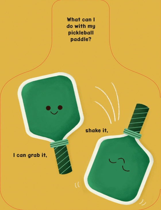 A playful illustrated graphic on a mustard yellow background showing two green pickleball paddles with simple faces and text that reads, 'What can I do with my pickleball paddle?' and 'I can grab it,' plus 'shake it,'.