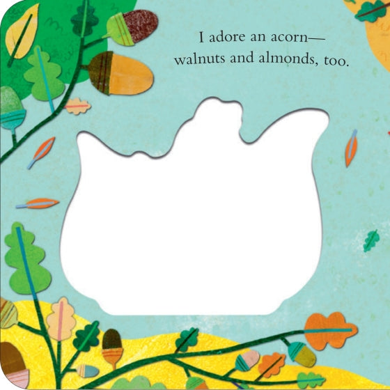 A children's book or craft page featuring a large white die-cut shape in the center, surrounded by an illustrated autumn border with acorns, leaves, and the text, 'I adore an acorn— walnuts and almonds, too.'.