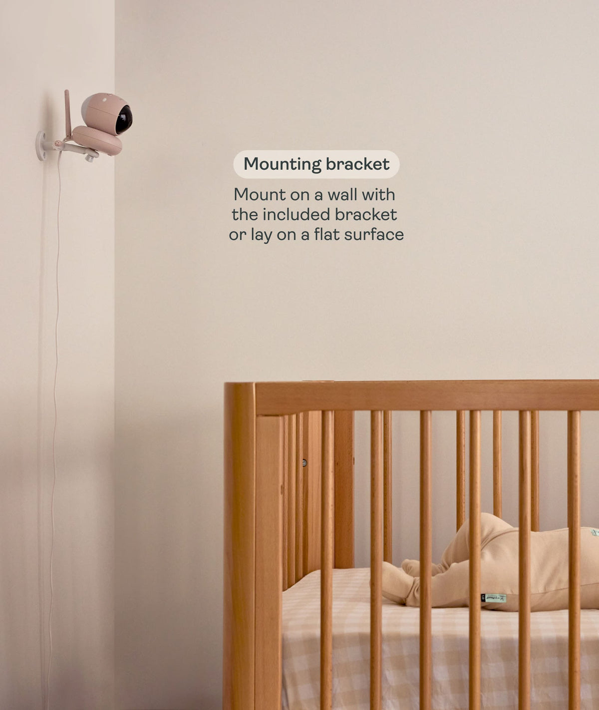 Baby monitor with mounting bracket near a crib in a room.