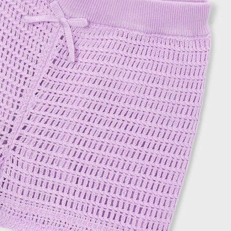 Close-up of a textured purple fabric with a white background