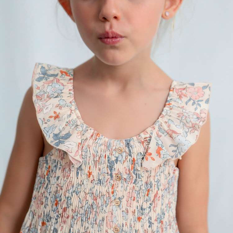 Young girl wearing a floral blouse against a plain background