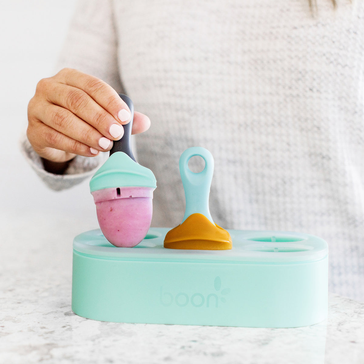 Colorful silicone baby teether set on a marble surface with a blurred background