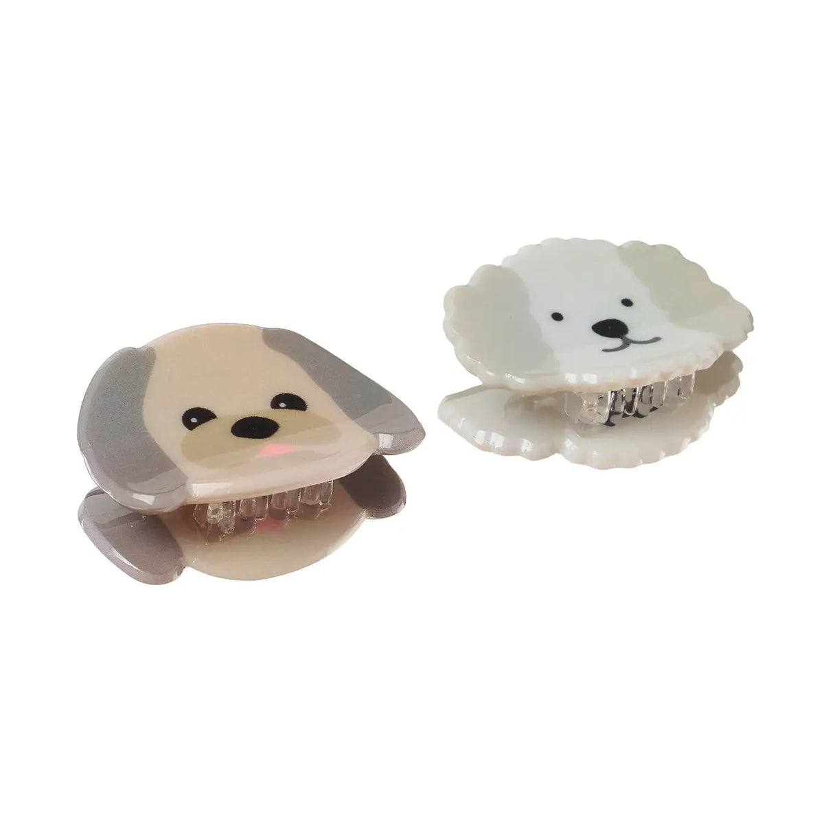Two small dog-shaped hair claw clips on a plain white background, one with a beige and gray dog face and one with a white dog face.