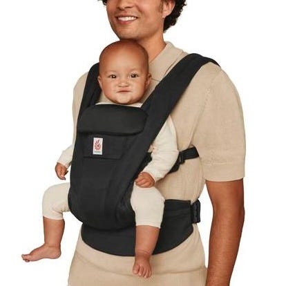 Person holding a baby in a black baby carrier on a white background
