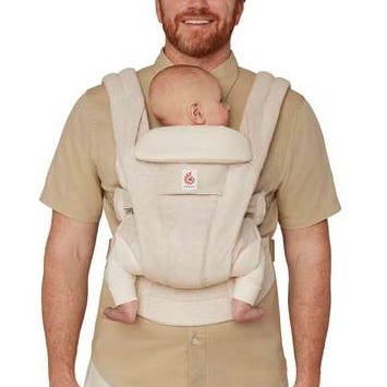 Man carrying a baby in a beige baby carrier.