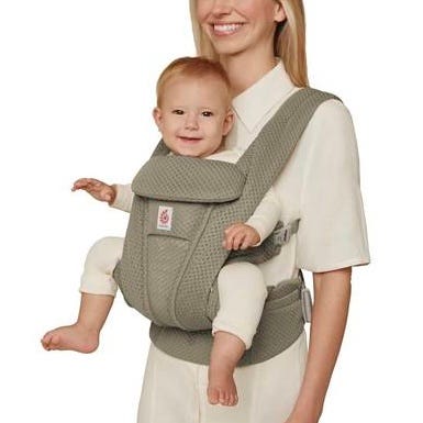 Woman carrying a baby in a green baby carrier.