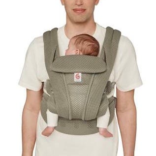 Person carrying a baby in a green baby carrier.
