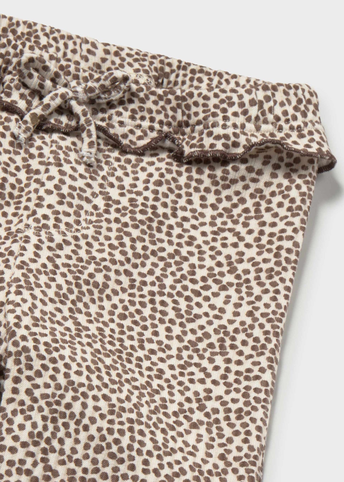 Leopard print pants with ruffled waistband on a light gray background
