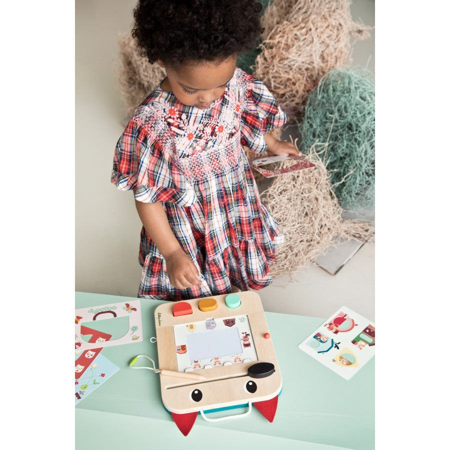 Child playing with a wooden toy on a light green surface