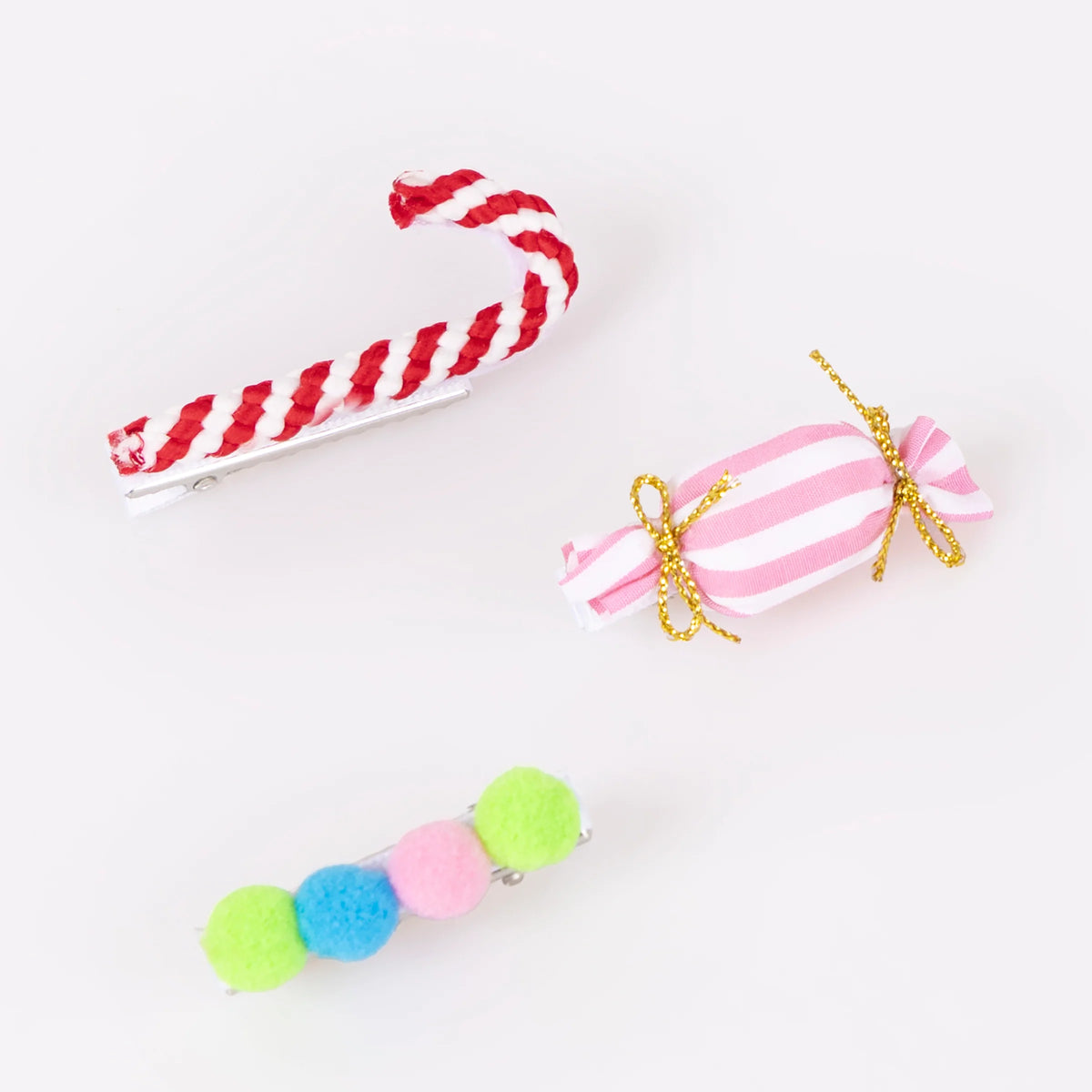 Textured Christmas Hair Clips by Meri Meri, featuring cute festive designs like a candy cane, a pink-and-white striped candy, and colorful pompoms.