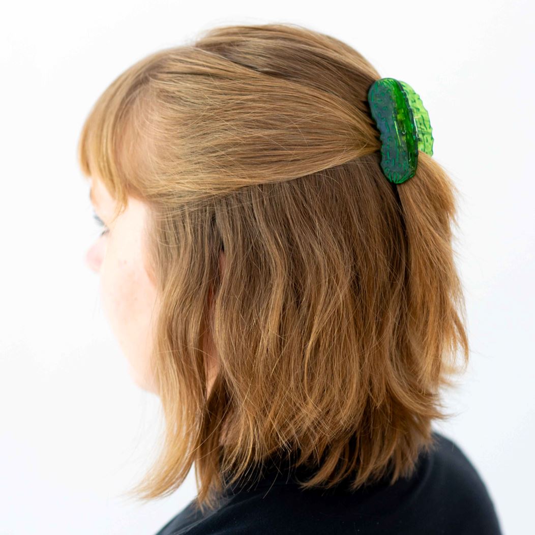Person with a green hair accessory in their hair on a white background