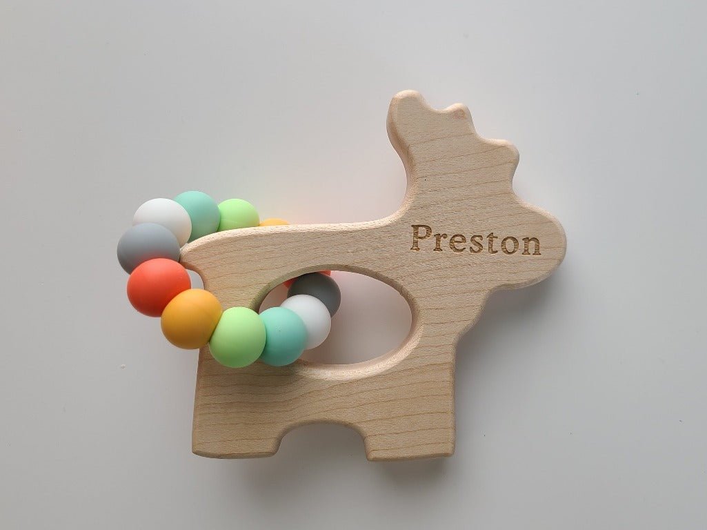 Wooden teething ring with colorful beads and 'Preston' engraving on a light gray background
