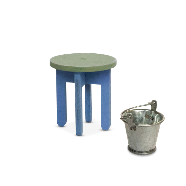Small round stool with green top and blue legs next to a metal bucket on a white background