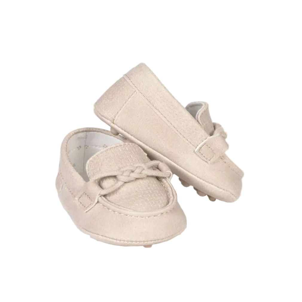Pair of beige baby shoes on a white background