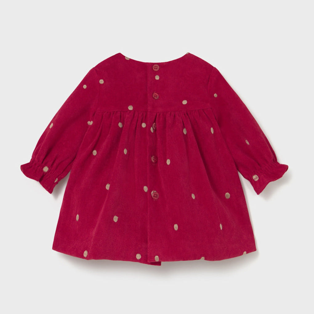 Red dress with white polka dots on a light gray background