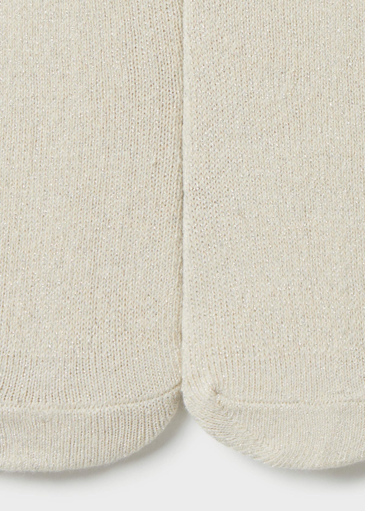 Close-up of a pair of off-white knit socks showing the ribbed texture and toe seams.