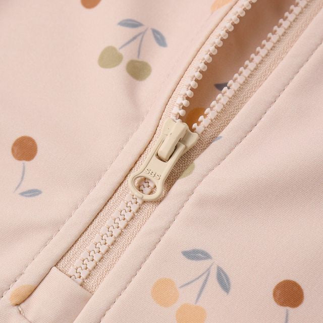 Close-up of a zipper on a pink fabric with floral patterns