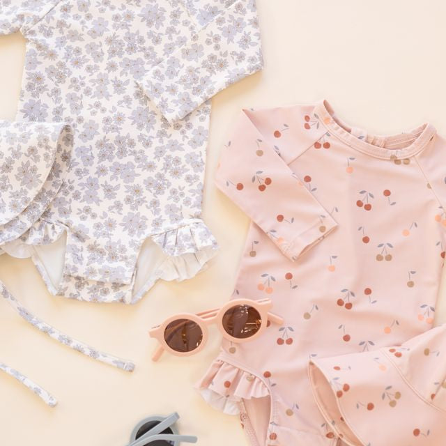 Two children's outfits with floral and polka dot patterns on a light background.