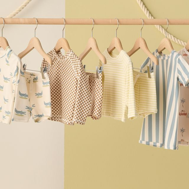 Children's clothing on hangers against a colorful background