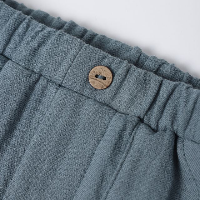 Close-up of blue fabric with a button on a white background
