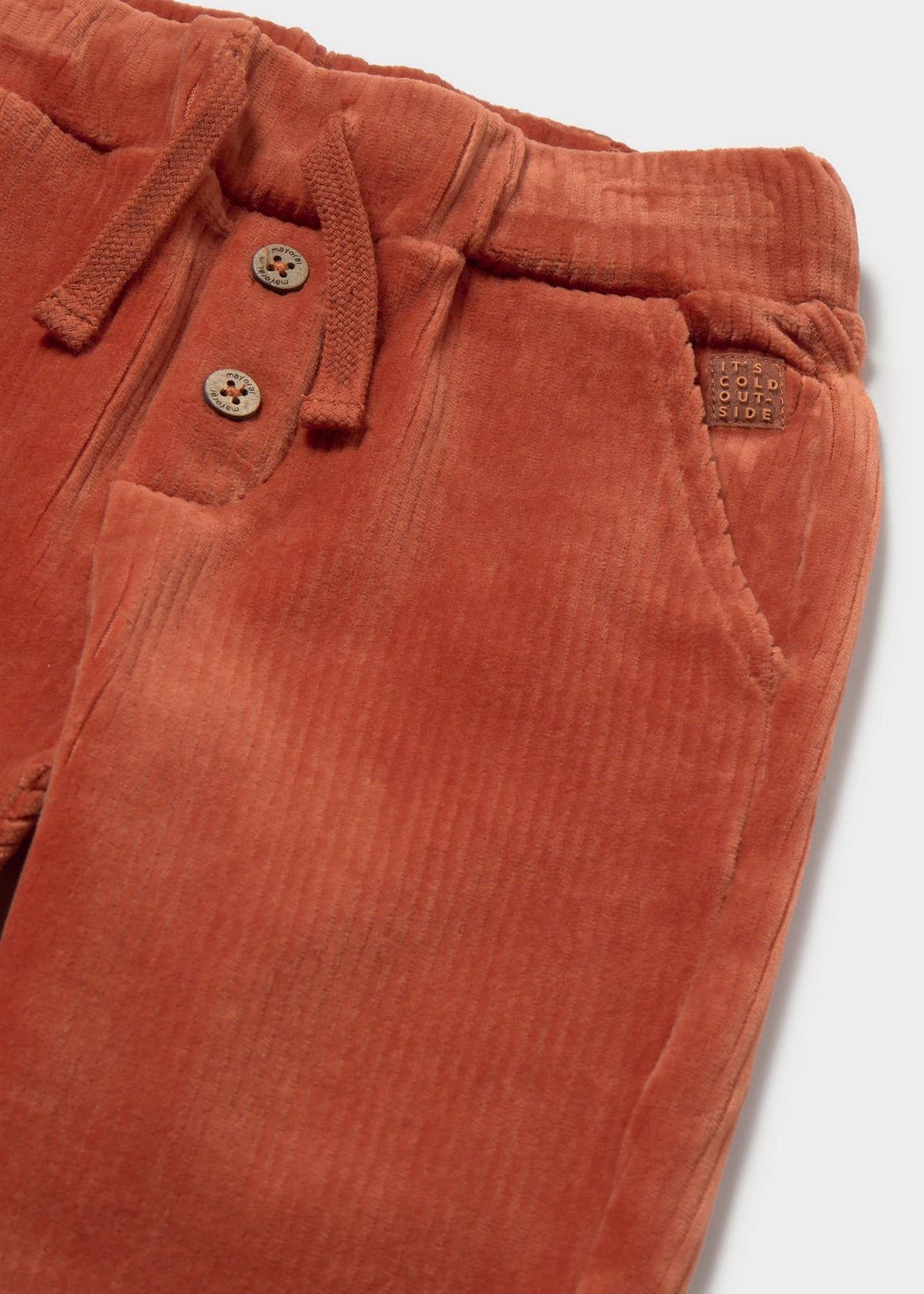 Close-up of the Mayoral baby corduroy jogger trousers in a terracotta/teja orange color with a soft textured finish.