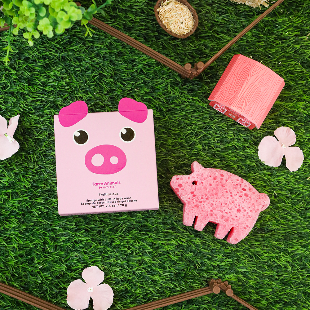 Pink pig-shaped product with packaging on a grassy background