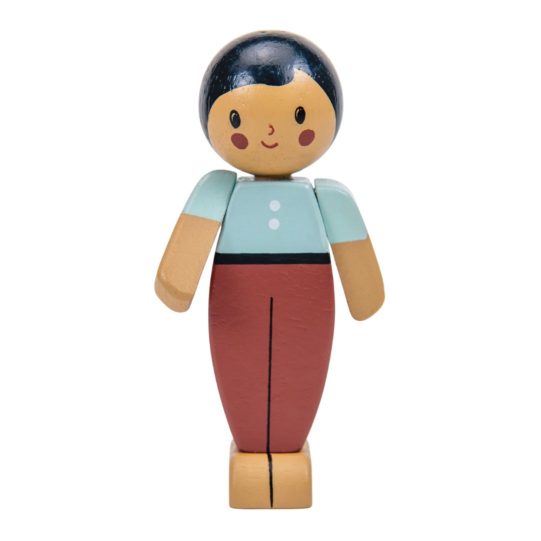 Wooden toy figure with blue top and red pants on a white background