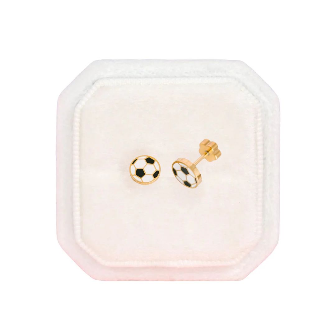 Pair of gold and black checkered earrings in a pink jewelry box on a white background