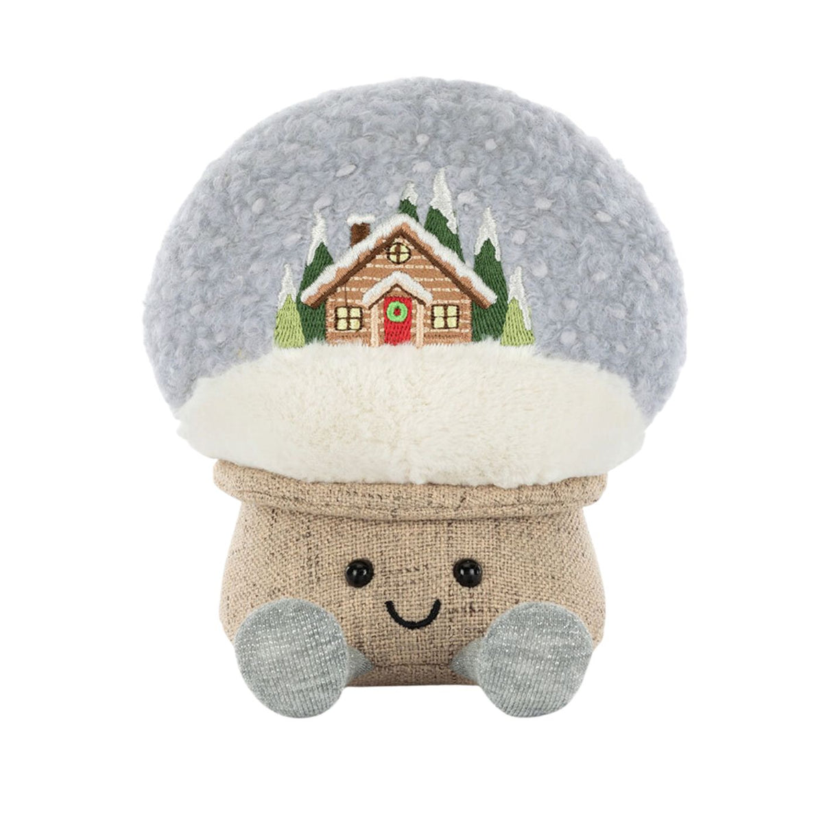 Plush toy with a snow globe design featuring a house and trees on a white background