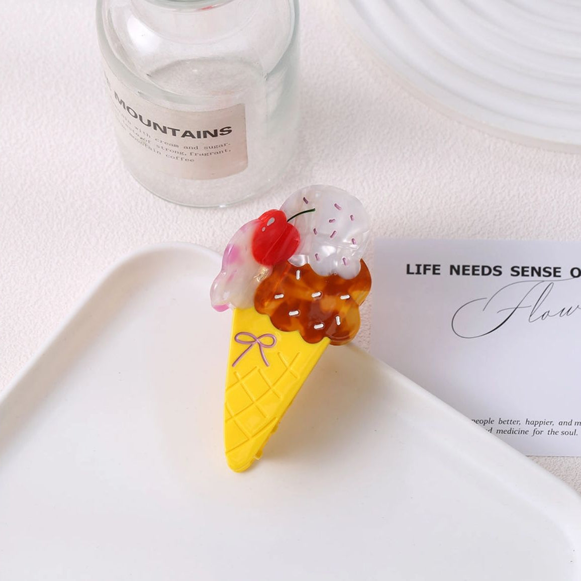 Ice cream cone-shaped object with cherry on top on a white surface
