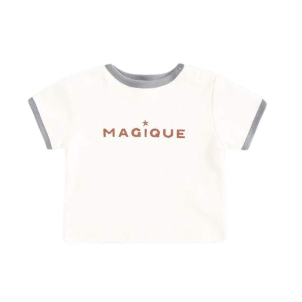 A baby ringer t-shirt in off-white with gray trim on the crew neck and sleeve cuffs, featuring the word 'MAGIQUE' printed in a dusty rose color across the chest.