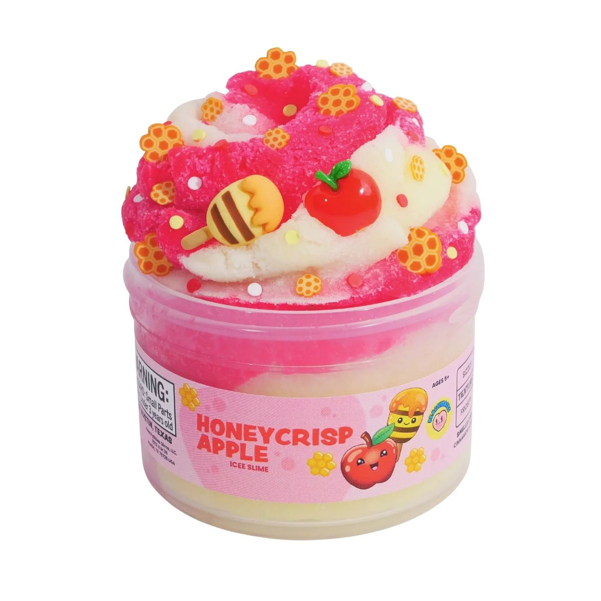 A jar of Honeycrisp Apple ice slime with a pink and white layered base, topped with a decorative swirl of pink slime, yellow honeycomb sprinkles, a red apple charm, and a bee topper. The container features a pink label with the Honeycrisp Apple flavor name and cartoon graphics.