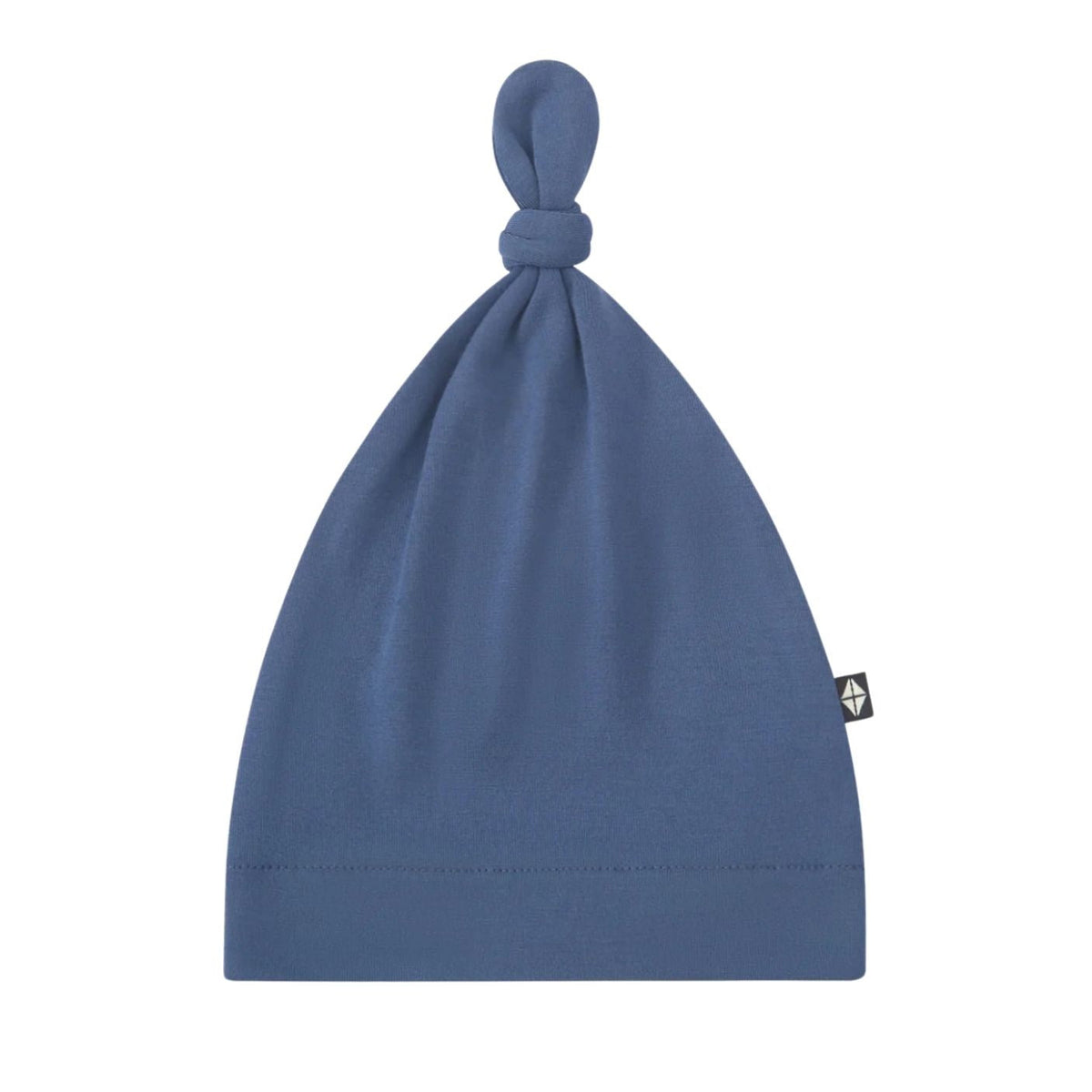 A dusty blue knit beanie hat with a knotted top and a small black brand tag on the side, shown against a plain white background.