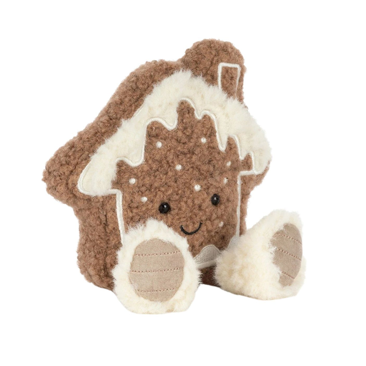 A plush toy shaped like a gingerbread house with cream-colored icing and feet, photographed on a clean white background.