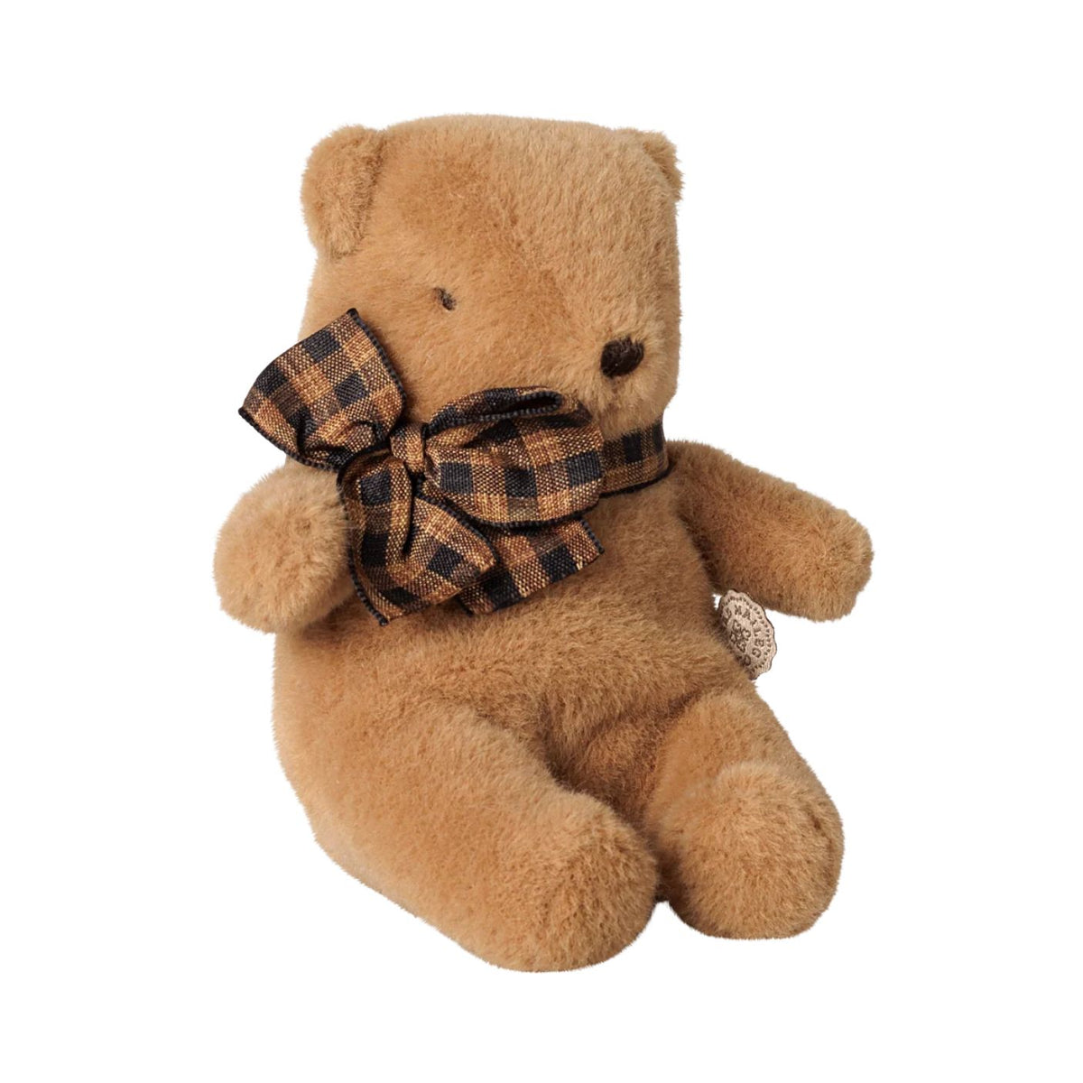 A plush teddy bear in a soft brown color sitting upright, featuring a dark brown and beige plaid bow tied neatly around its neck.