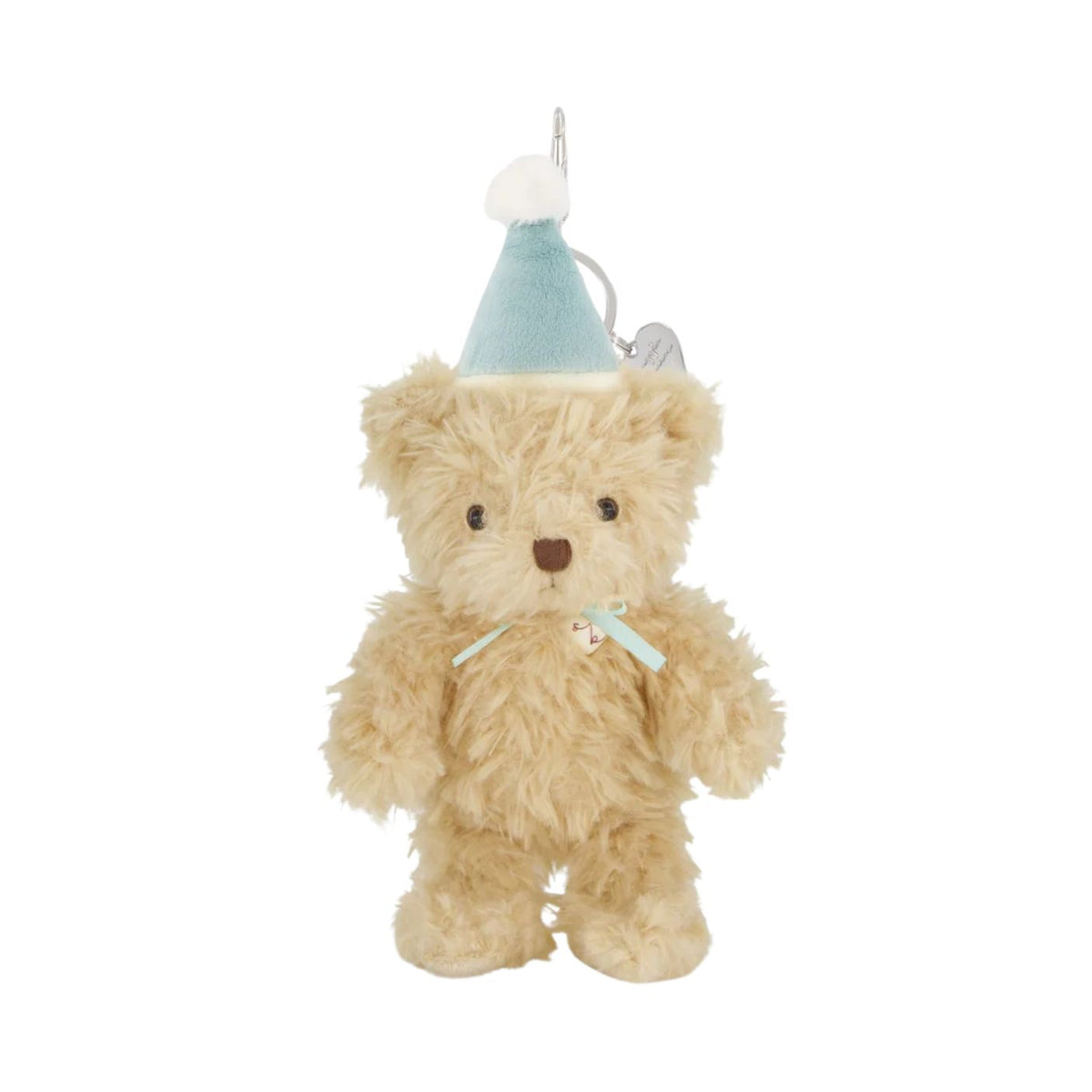 A fluffy, beige plush teddy bear keyring wearing a light blue party hat with a white pom-pom, accented with a matching light blue ribbon around its neck and a secure silver clasp at the top.