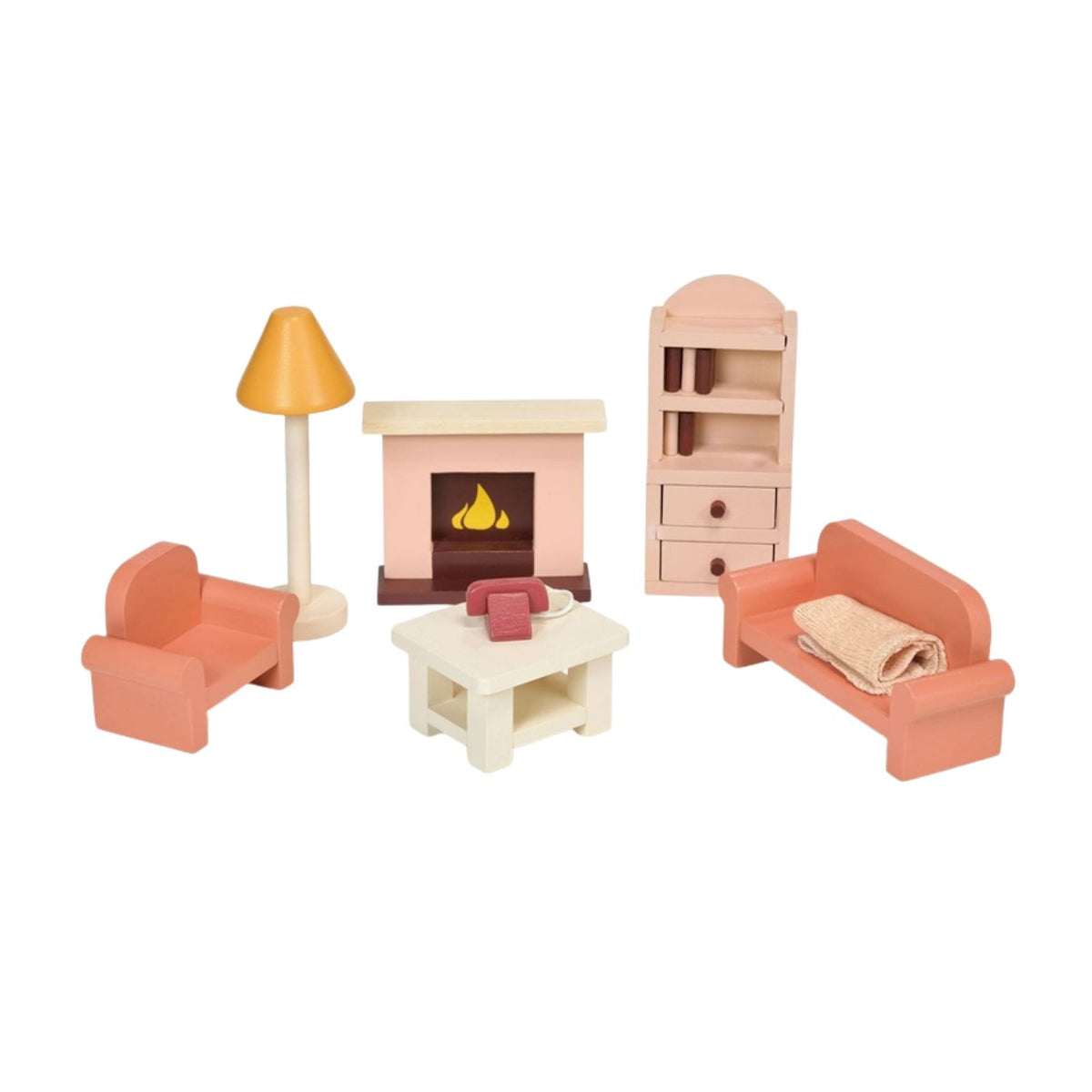 A white product photography studio shot featuring a wooden dollhouse furniture set by Mentari against a plain white background. The set includes a coral-pink sofa draped with a tan knitted throw blanket, two matching coral-pink armchairs, a beige coffee table topped with a small red telephone and another small object, a pale pink decorative fireplace with a lit fire graphic, a tall yellow standard floor lamp, and a natural wood bookcase filled with colorful miniature books and two small drawers.
