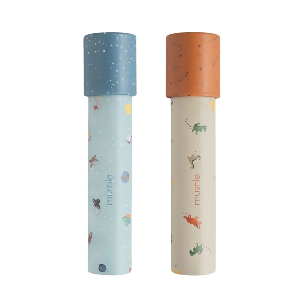 Two Mushie paper kaleidoscopes standing vertically against a white background, featuring the Space and Dinosaurs pattern with blue and orange caps.