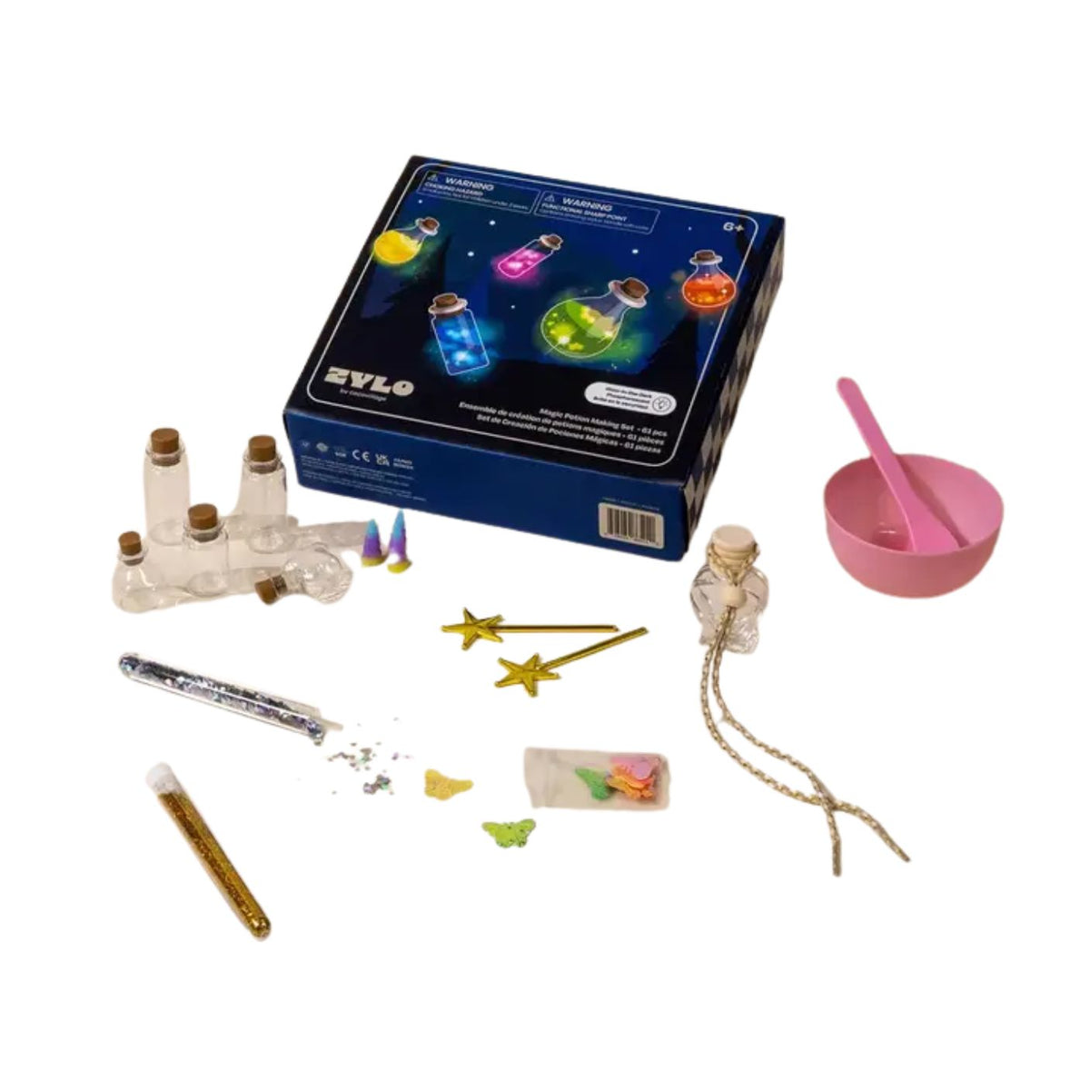 A children's craft kit with a blue box showing glowing potion bottles, plus scattered components including small glass bottles, a pink bowl with spoon, gold star-shaped pieces, a wand, beads, glitter, and other small accessories on a white background.