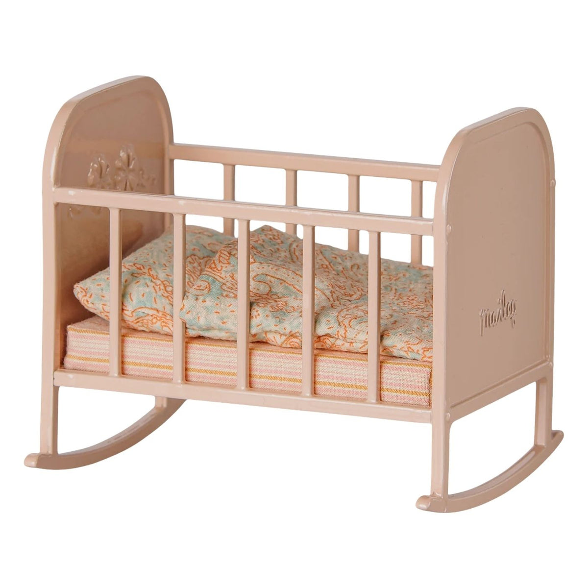 A miniature dollhouse rocking crib in a light peach-pink wood finish, styled with a peach and blue patterned quilt and pillow, on a solid white background.