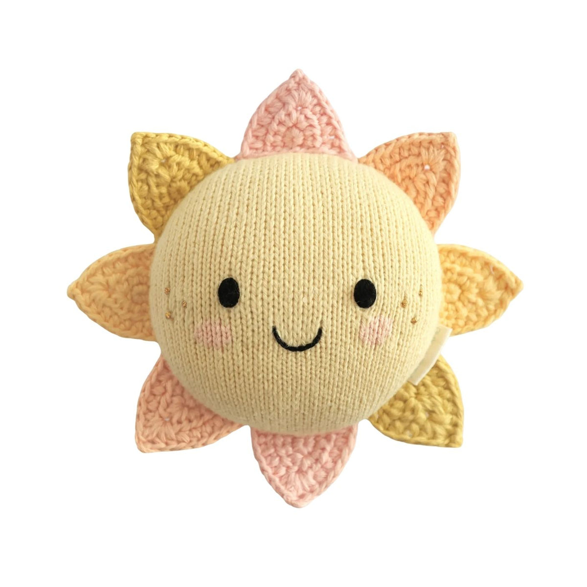 A knitted sun plush toy with a round cream-colored face, black embroidered eyes and smile, and soft yellow, peach, and pink rays, shown on a plain white background.