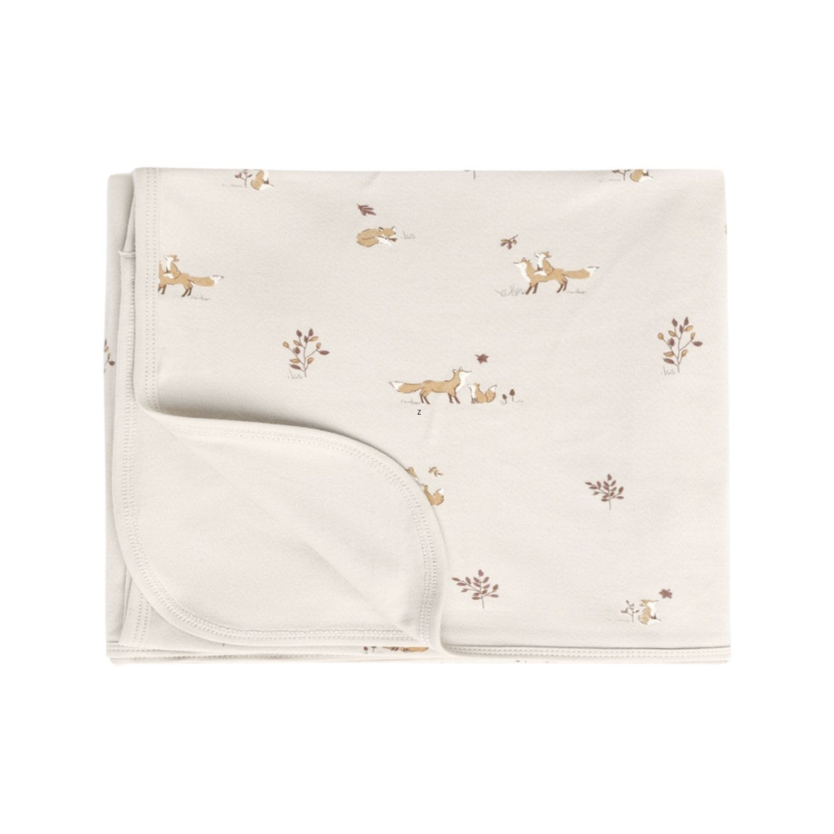 A folded cream-colored baby blanket featuring a delicate print of woodland animals, including foxes, rabbits, and leaves, on a solid white background.