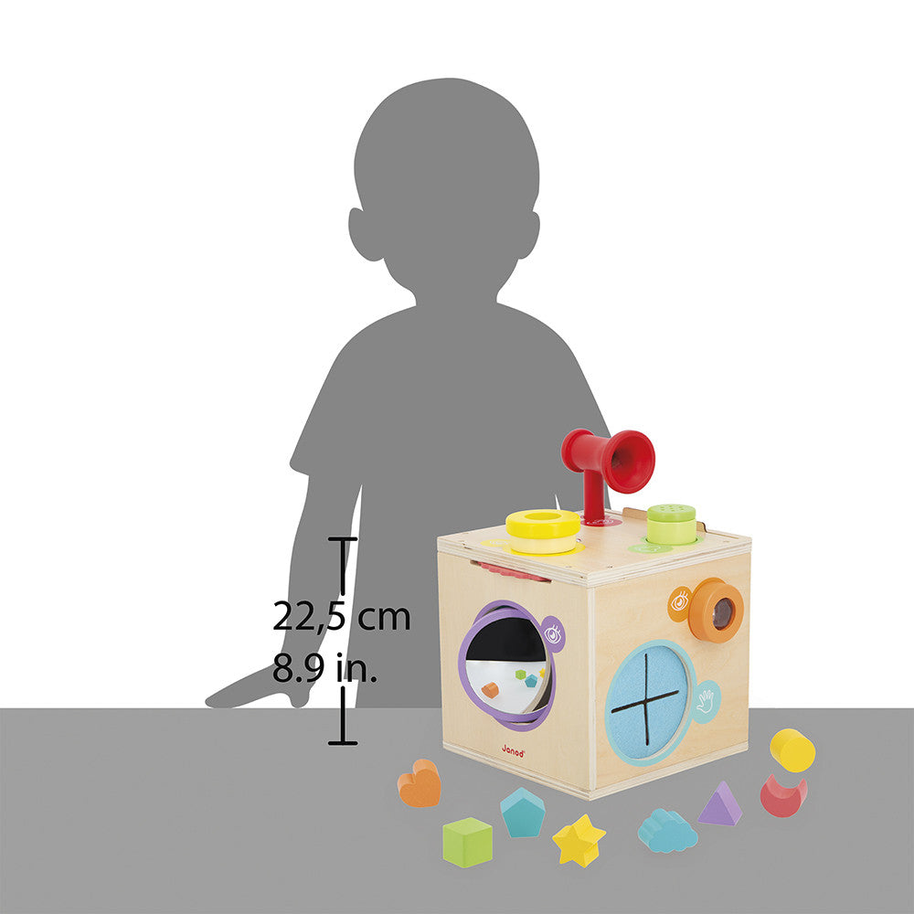 Wooden activity cube with colorful shapes and a mallet, shown with a child's silhouette for scale.