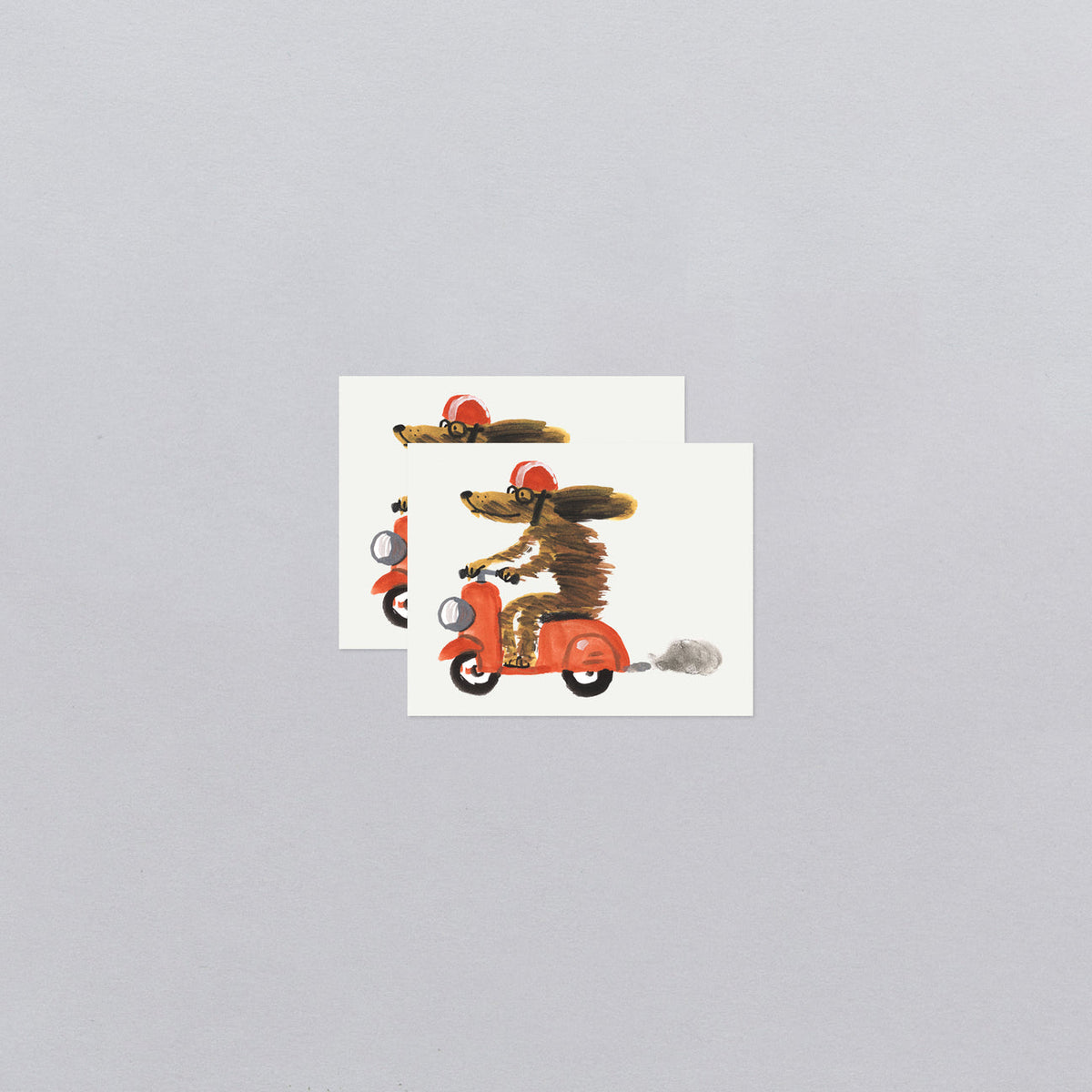 Two greeting cards with illustrations of a dog on a scooter and a cat on a motorcycle, on a light gray background.