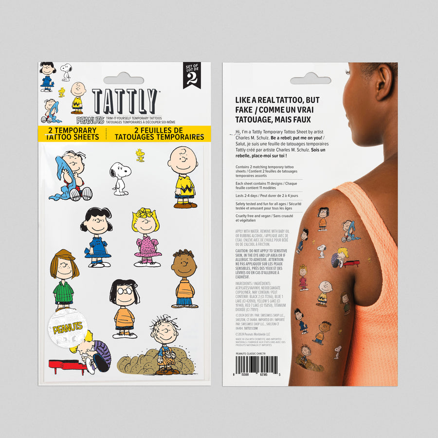 Tattly temporary tattoo packaging with Charlie Brown and friends design, showing a person with tattoos on a gray background.