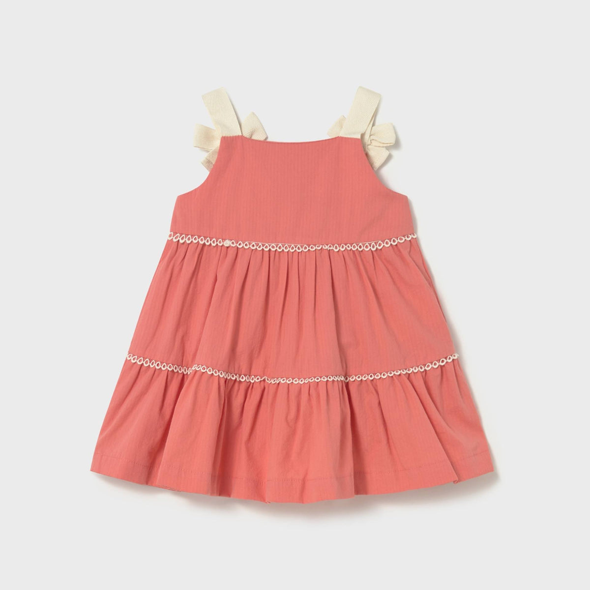 Coral dress with white trim on a light gray background
