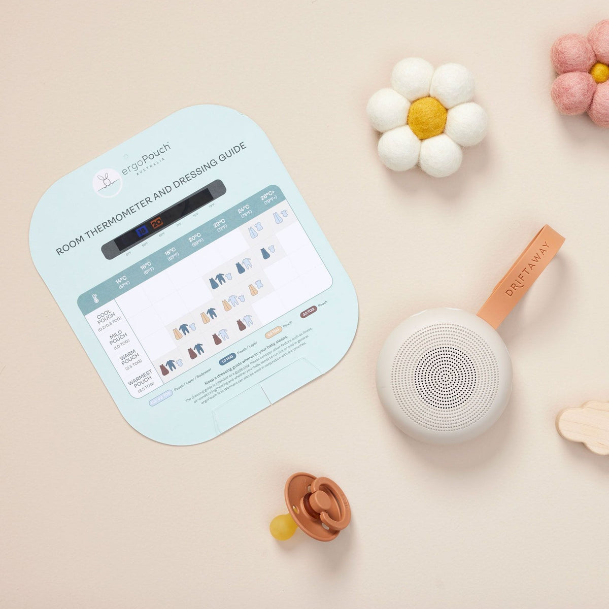 Baby monitor with digital display, toys, and a flower on a beige background