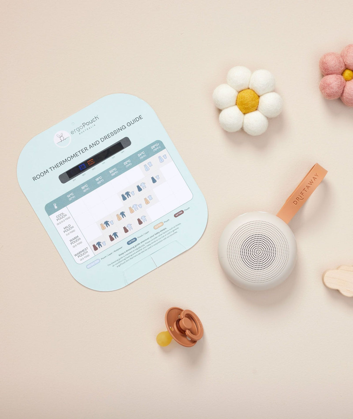 Baby monitor with digital display, toys, and a flower on a beige background