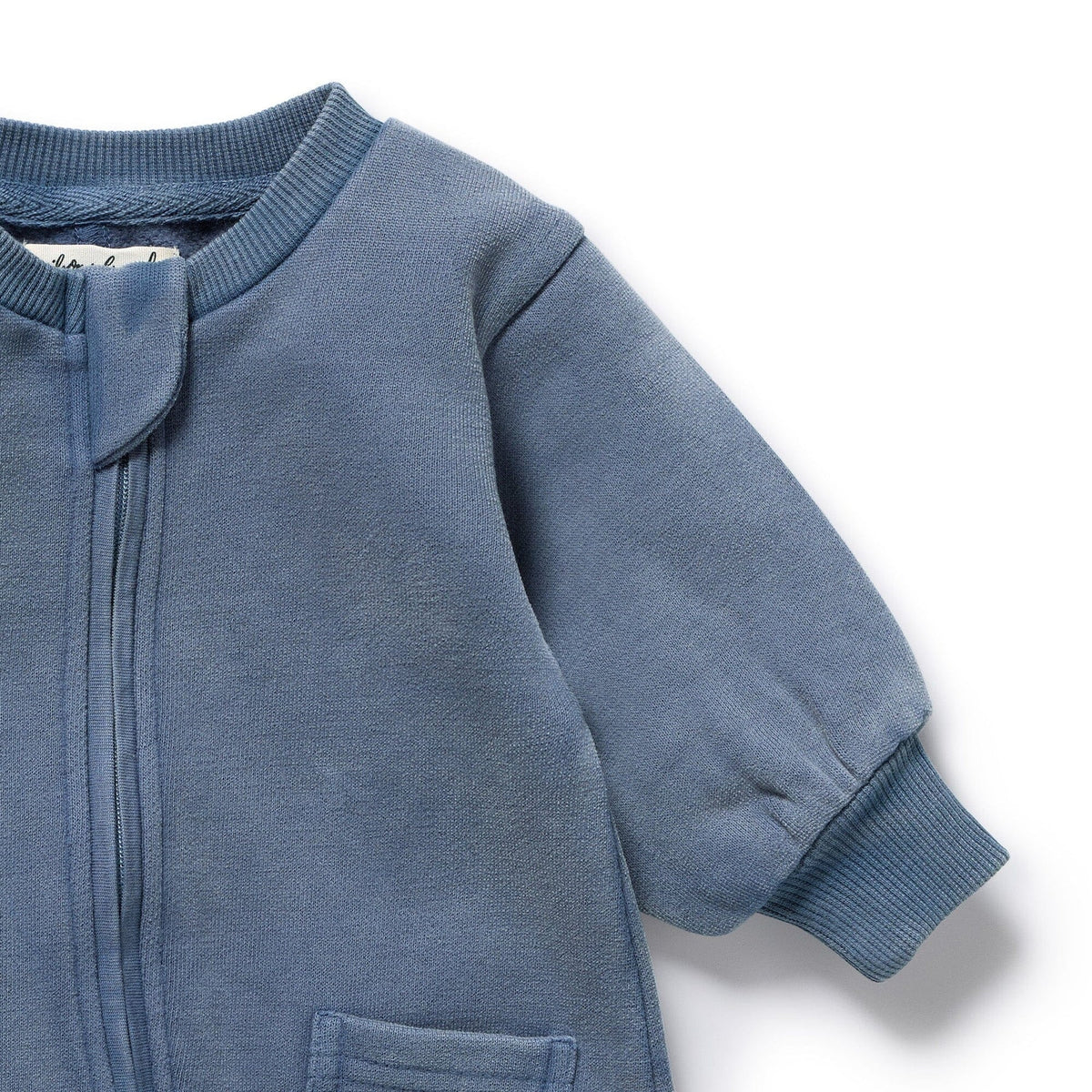 Close-up of a blue baby onesie with a zipper on a white background